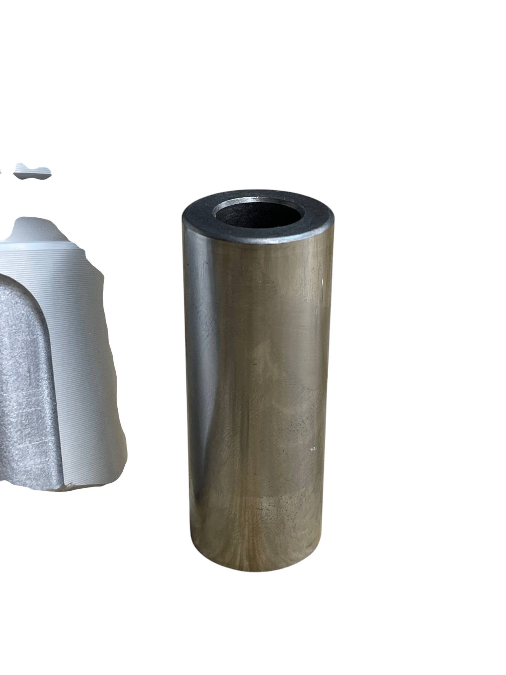 Bulón de acero endurecido de Innovaciones Industriales junto a un pistón de aluminio para motor de combustión